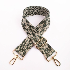 Detail of green and beige ethnic embroidery bag strap with gold metal swivel hooks