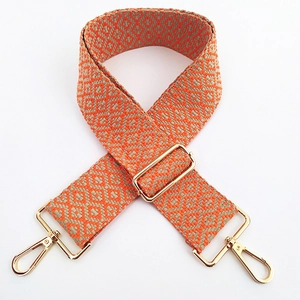 Detail of bohemian orange and grey geometric embroidery on adjustable bag strap