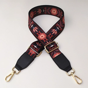 Detail of adjustable wide vintage ethnic floral pattern bag strap with gold metal hooks
