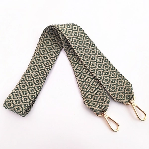 Detail of colorful geometric jacquard wide shoulder strap with gold metal lobster clasps