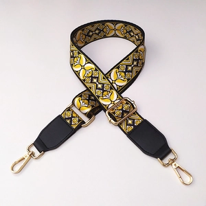 Close-up of ethnic weave bag strap with yellow floral pattern and gold metal hooks