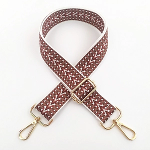 Détail d'une bandoulière brodée de 3,8 cm avec motif ethnique et boucles dorées