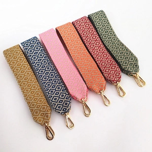 Close-up of geometric embroidered cotton bag straps with polished gold metal swivel hooks