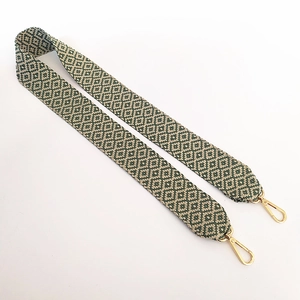 Detail of green and beige geometric jacquard woven strap with gold metal lobster clasp