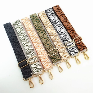 Detail of seven adjustable jacquard woven bag straps with gold metal lobster clasps