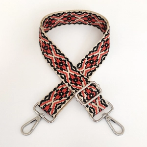 Macro shot of 3.8cm jacquard bag strap with red geometric pattern and silver lobster clasps