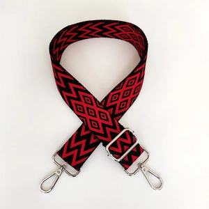 Close-up of retro geometric red and black woven bag strap with silver metal buckles