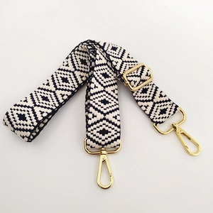Close-up of adjustable woven shoulder strap with black and white geometric diamond pattern