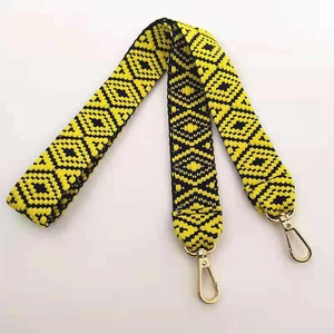 Close-up of ethnic geometric pattern woven bag strap with golden metal swivel hooks