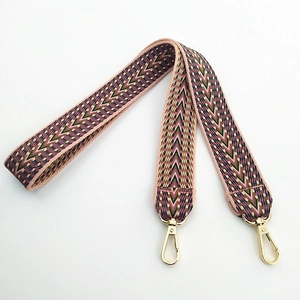 Détail d'une bandoulière brodée de 3,8 cm avec motif à chevrons et crochets dorés
