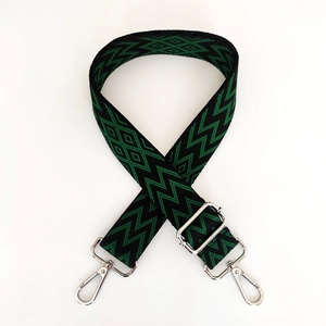 Close-up of geometric jacquard shoulder strap with silver metal lobster clasps and slider