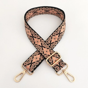 Detail of jacquard wide bag strap with geometric patterns and gold metal lobster clasps