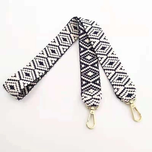 Detail of ethnic geometric patterned wide shoulder strap with gold swivel lobster clasps