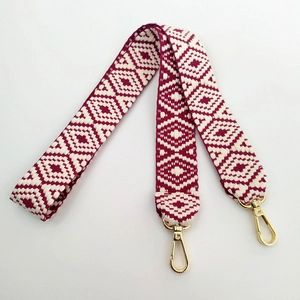 Detail of bohemian geometric woven strap in burgundy and cream with gold alloy hooks