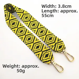 Close-up of geometric yellow and black woven bag strap with golden lobster clasps
