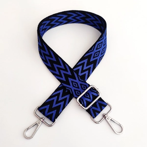 Detail of adjustable wide shoulder strap with blue wave patterns and silver metal buckles