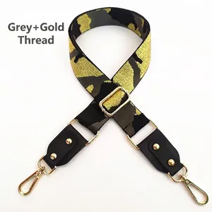 Detail eines verstellbaren Camouflage-Taschengurts in Grau und Gold mit Metallschließe