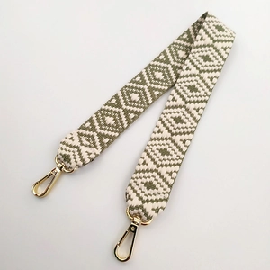 Close-up of geometric pattern cotton woven bag strap with golden lobster metal clasps