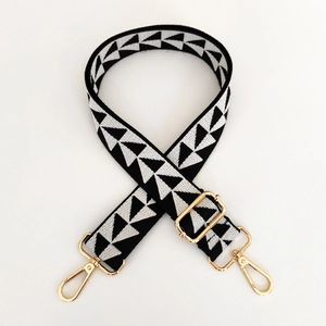 Close-up of adjustable shoulder strap featuring black and white geometric triangle patterns