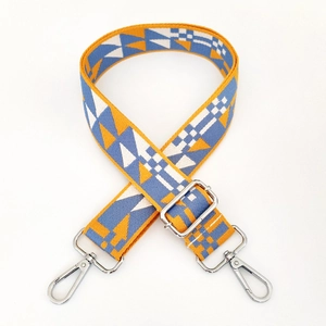 Detail of colorful geometric woven strap with thick cotton webbing and silver metal clasps