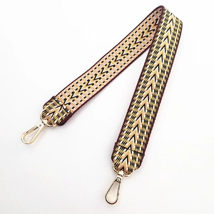 Détail de la bandoulière tissée à motif chevron avec mousquetons dorés clairs