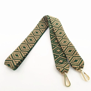Close-up of ethnic geometric jacquard bag strap with gold metal snap hooks