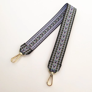 Détail de la bandoulière brodée épaisse avec motif violet et mousquetons dorés brillants