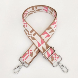 Detail of adjustable geometric patterned bag strap with silver metal swivel hooks
