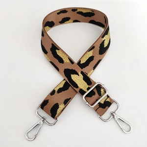 Detail view of leopard print bag strap with gold metallic threads and silver lobster clasps