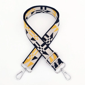 Close-up of geometric jacquard wide shoulder strap with silver metal buckle and lobster clasp