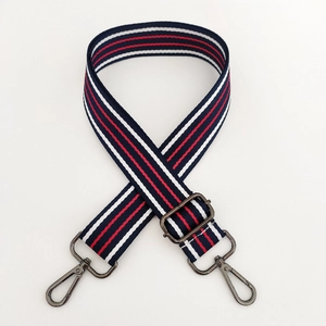 Detail of adjustable red white and blue striped woven bag strap with metal clasps