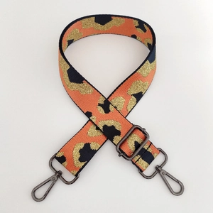 Close-up of leopard pattern woven strap with gunmetal hardware and adjustable buckle