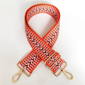 Detail of adjustable geometric V-pattern woven strap with gold metal hooks for handbags