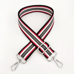 Close-up of adjustable striped handbag strap with silver metal hooks and buckle