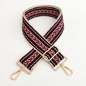 Macro shot of ethnic geometric jacquard bag strap with gold metal hooks and buckle