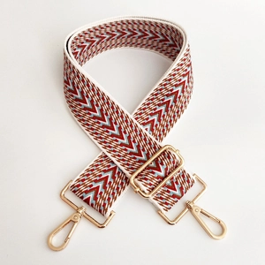Macro detail of red and blue geometric woven wide strap with gold metal lobster clasps