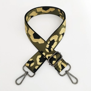 Detail of adjustable leopard print bag strap with gold accents and metal swivel hooks