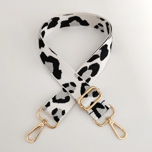 Close-up of leopard print nylon bag strap with gold metal hooks and adjustable buckle