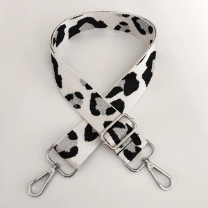 Detailed view of silver lobster clasps and leopard pattern on adjustable bag strap