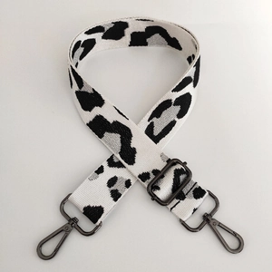 Close-up of leopard print nylon bag strap with gunmetal swivel hooks and adjustable buckle
