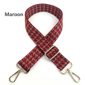 Close-up of adjustable purple houndstooth fabric bag strap with gold lobster clasps