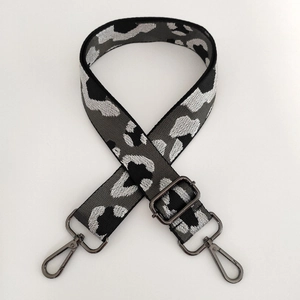 Macro shot of leopard print jacquard strap with adjustable gunmetal buckle and clips