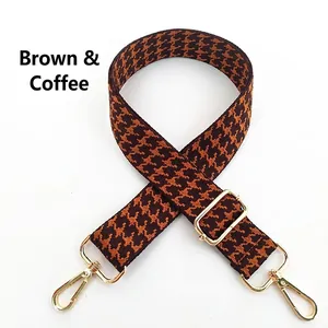 Detail view of adjustable houndstooth bag strap in brown coffee with gold metal hooks