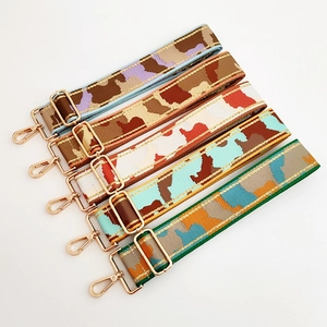 Close-up of adjustable jacquard replacement straps with gold hardware for handbags