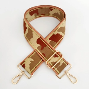 Detail of camouflage bag strap with gold threads and adjustable metal buckles