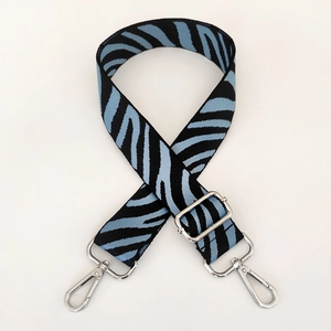 Detail of adjustable nylon camera bag strap with blue and black zebra pattern and metal hooks
