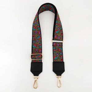 Close-up of ethnic floral jacquard strap with gold buckle and black leather ends