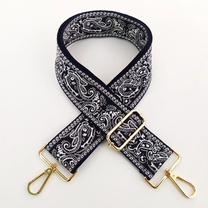 Detail of bohemian paisley embroidery on navy wide strap with gold metal hardware