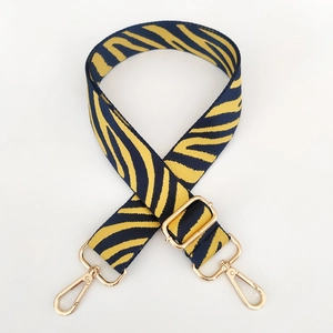 Detail of adjustable nylon strap with yellow and blue tiger stripes and gold metal hardware
