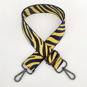 Detail of wide zebra pattern bag strap with dark grey metal lobster clasps